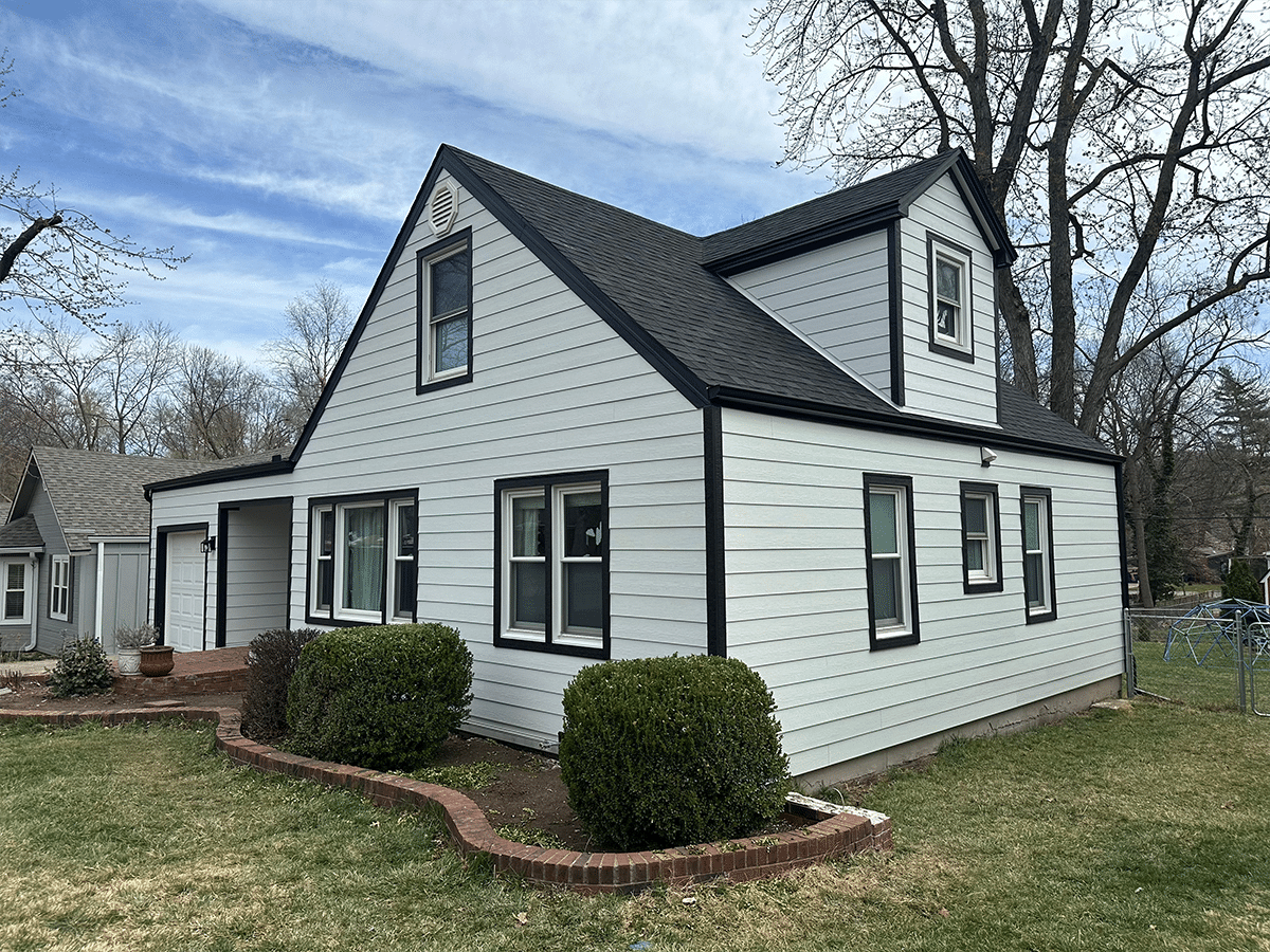 Angled shot of blue house with James Hardie siding with a brick chimney on the right side.