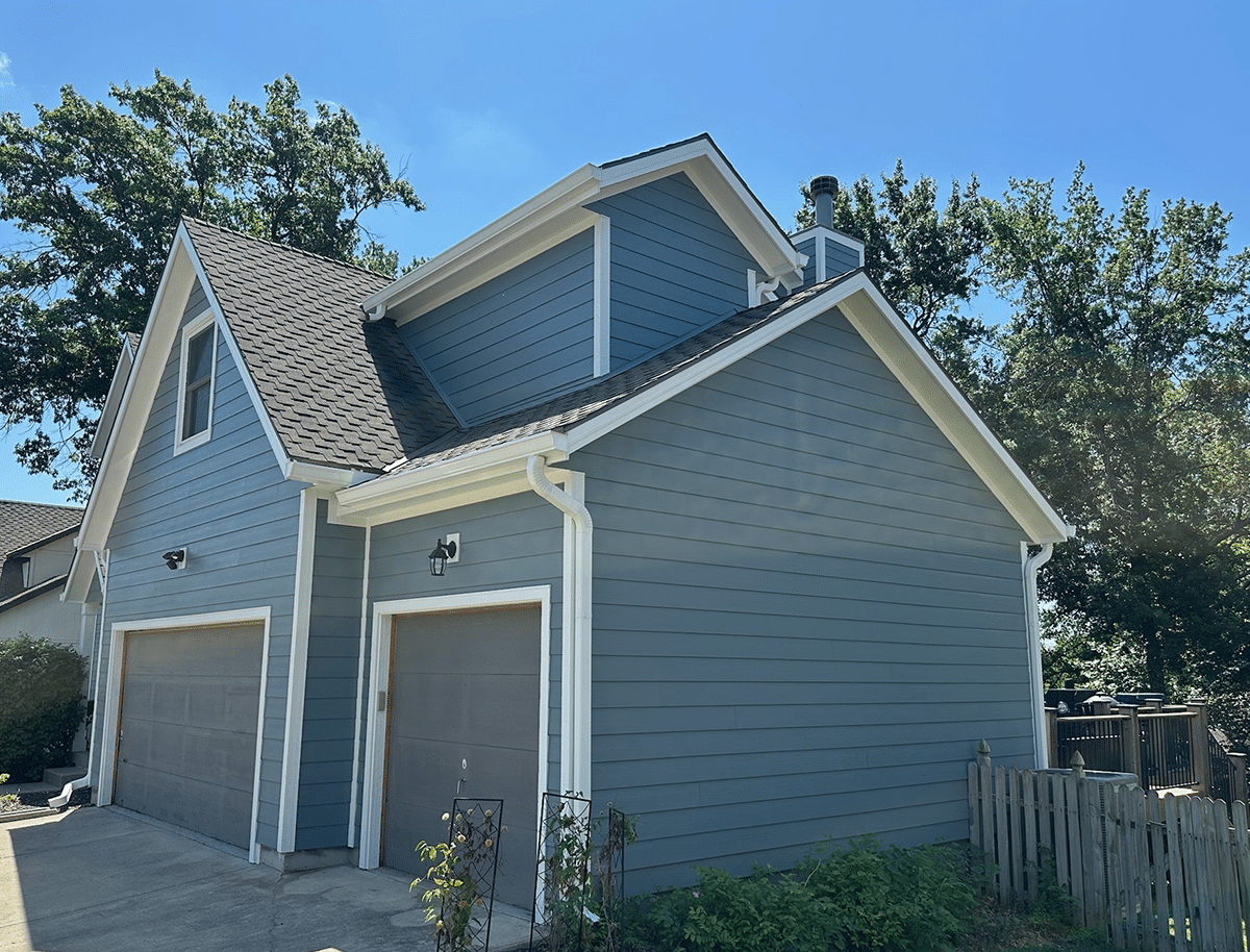 Angled shot of blue house with James Hardie siding with a brick chimney on the right side.